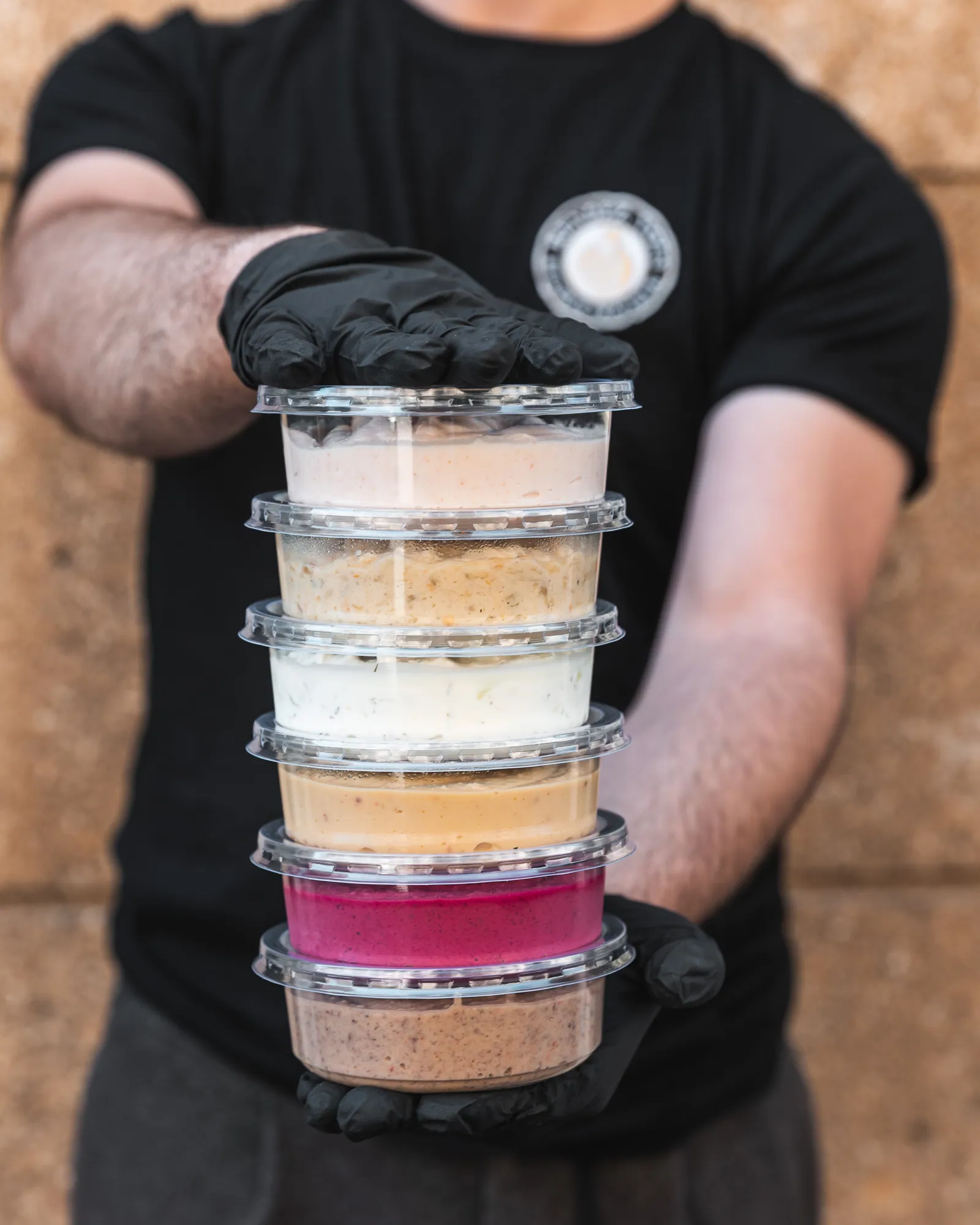 Une pile de pots de mezzés tenue au comptoir de l’épicerie