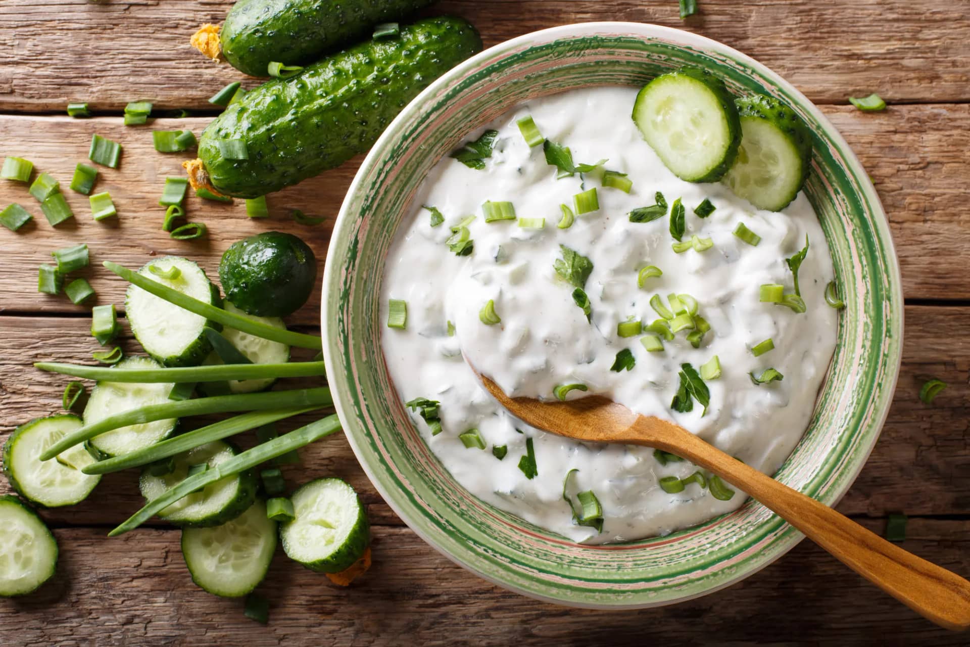 Un bol de tzatziki au concombre et à la ciboulette, sur une table en bois